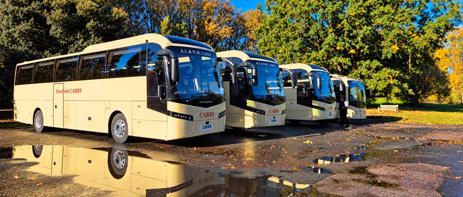 Carrs coaches reflected in autumn puddles